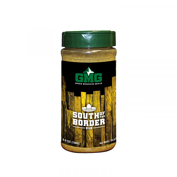 South of the Border dry rub by Green Mountain Grills in a clear jar with a green lid, featuring a wooden background and text highlighting flavor enhancement for grilling.