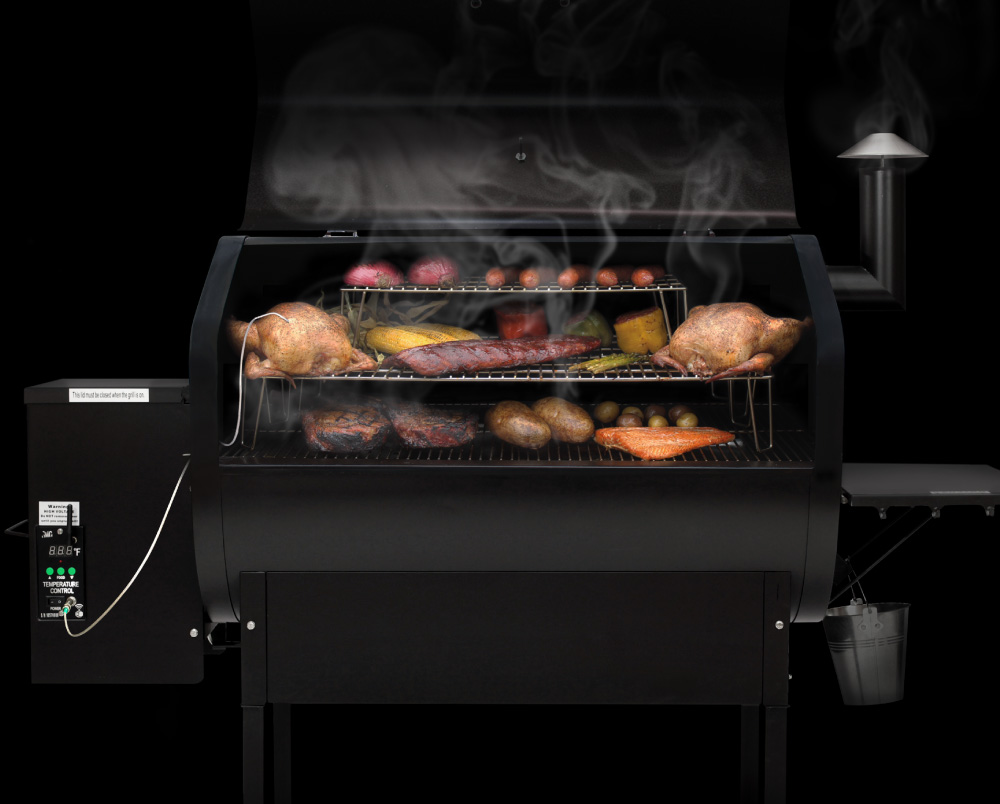 Wood-fired grill with dual fan system, featuring smoked meats and vegetables, showcasing large grilling space and digital temperature control, emphasizing Green Mountain Grills' innovative cooking technology.