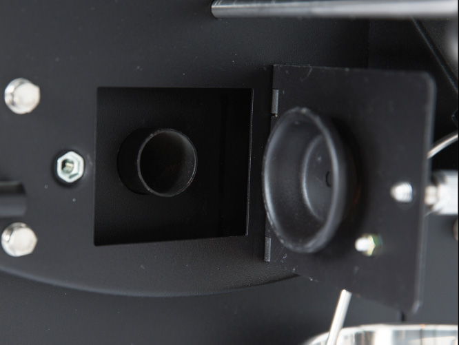 Ash clean-out door and vacuum hose connection point on Green Mountain Grills TREK Prime WiFi pellet grill for efficient ash removal.